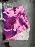 Bedspread folded showing floral side and light pink reverse