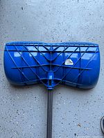 Rear of blue plastic shovel scoop with reinforcement ribs and logo tag