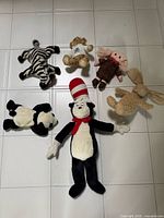 All six stuffed toys displayed on tiled floor
