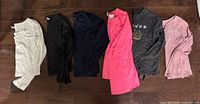 Six shirts laid flat showing colour and style