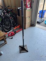 Full view of hand tamper standing upright