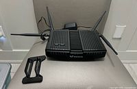 Top view of VMedia modem-router with four antennas, power adapter and stand visible