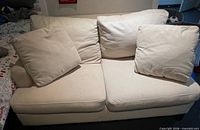 Front view of cream loveseat with cushions