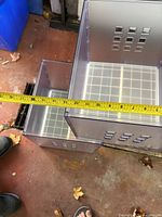 Two clear IKEA Kallax boxes with tape measure showing dimension around 13.5 inches