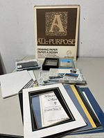 Full lot overview showing drawing pad, frame, greeting card packs, canvas boards, decorator mats, accessory tin and loose items