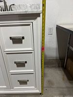 Front view of vanity showing drawers, cabinet door, tape measure indicating height