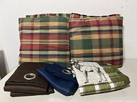 Brown and navy drapes, plaid cushions displayed upright