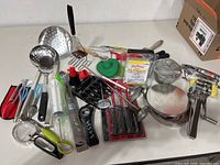 All items spread on table including pasta maker, utensils, thermometers, pie weights