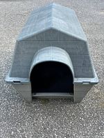 Front view of grey plastic dog house assembled