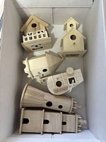 Top view of six unpainted wooden birdhouses in cardboard box