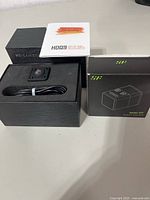 HDQ9 camera in open presentation box alongside boxed Mini DV camera and accessories