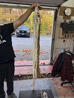 Person holding bundled white and brown macrame hangers showing full length