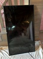 front view of cracked flat-panel TV leaning against wall