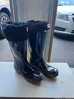 Front view of both black Hunter kids rain boots showing gloss finish and cuff liners