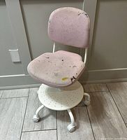 Front view of pink children’s swivel chair showing seat, backrest, footrest and wheels