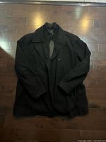 Front view of Kenneth Cole Reaction black coat laid flat