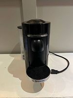 Front view of Nespresso coffee machine showing drip grid and chrome trim