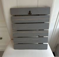 Front view of grey wooden slatted clipboard showing clip and slat construction