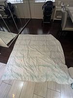 Full view of bedspread laid flat showing size and stain