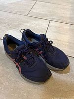 Pair of navy Asics running shoes showing uppers and laces
