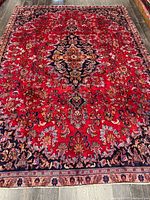 Full view of red Persian rug with central medallion