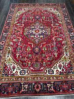 Full view of entire Persian Tabriz rug showing pattern, borders, and colors