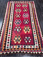 Full view of handmade kilim rug showing entire geometric design and borders