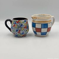 Front view of both creamers showing patterns and handles