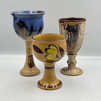 Frontal view of the three ceramic goblets showing colors and shapes