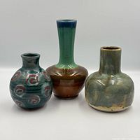 Front view of three pottery vases showing shapes and glaze colours