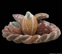 front view of clay bowl filled with five fruit pieces