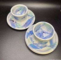 Pair of glazed ceramic egg cups on saucer bases