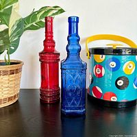 Front view of cobalt blue and red glass bottles on shelf