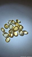 Group of golden yellow citrine cabochons on white surface