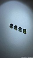 Four loose round sapphires under spotlight