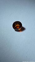 Front view of round orange Spessartite garnet