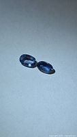 Both sapphires side by side on neutral background
