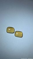 Two cushion-shaped honey chalcedony cabochons on neutral background