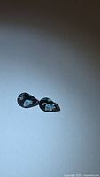Pair of pear-cut Tanzanite stones on white background