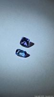 Both tanzanites side by side on neutral background