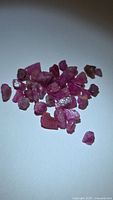 pile of rough pink-red ruby crystals on white background