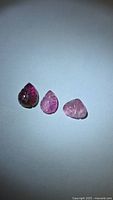 Front view of three pink tourmaline leaf-cut stones on white background