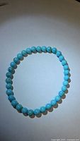 Full view of bracelet laid flat showing round turquoise beads