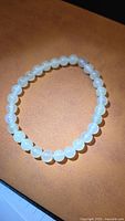Full view of white jade beaded bracelet on surface