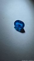 Front view of oval deep blue apatite on white background