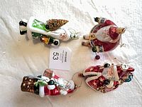 All four Santa glass ornaments laid out showing fronts
