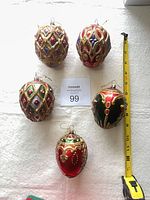 Overview of five egg-shaped ornaments with tape measure
