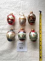 Six assorted egg-shaped ornaments with measuring tape for scale