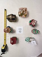 All seven building ornaments arranged with measuring tape for scale and lot card