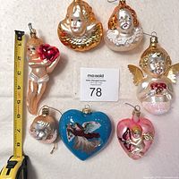 All seven glass ornaments laid out with measuring tape for scale
